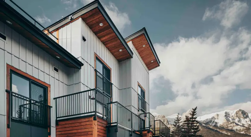 view of modern siding of the Basecamp Resort with the Rocky Mountains in the background