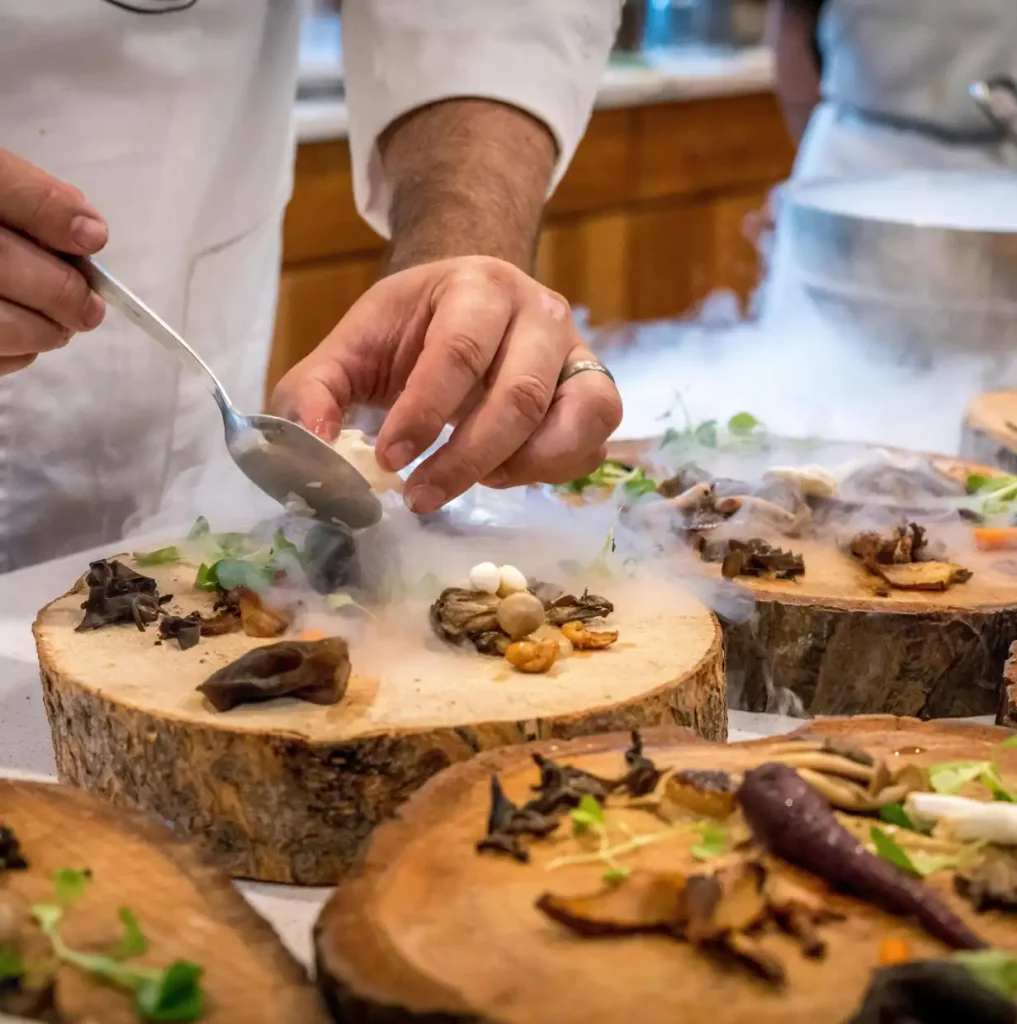 close up of chef hands plating a meal Reply